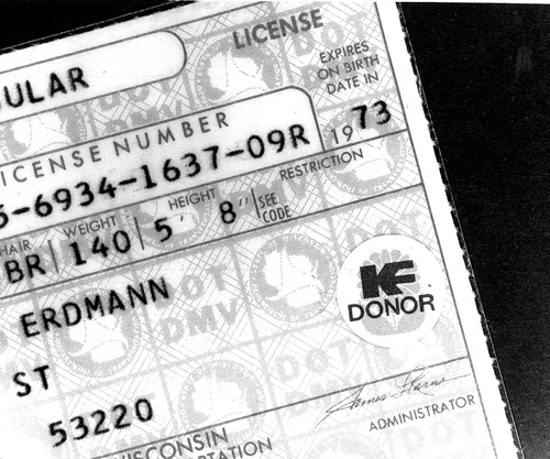 Close up of a corner of a Wisconsin Drivers license from 1973 showing the Donor Dot sticker